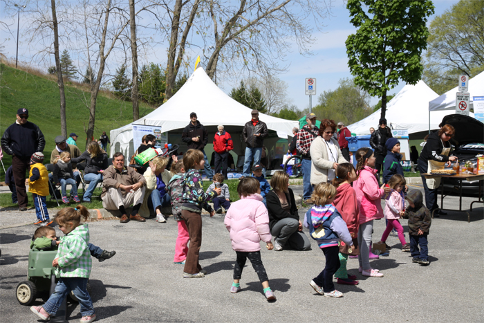 adults and children gather around festival tents