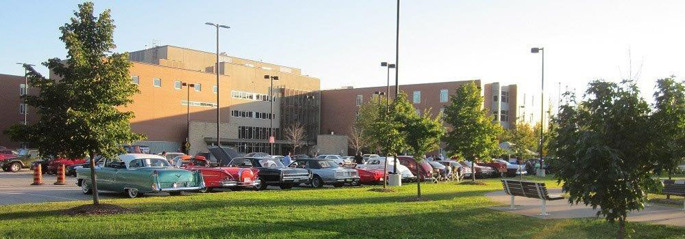 Exterior of Huron Lodge with a row of classic cars parked outside