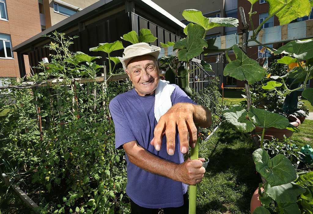 An older gentleman smiles in a garden outside of Huron Lodge