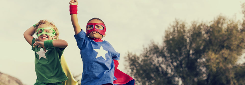 Two boys dressed as superheroes play outside