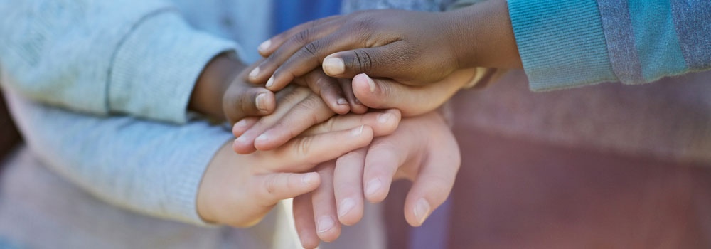 Children stack their hands together