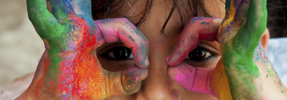 Child looking throw pained hands like binoculars