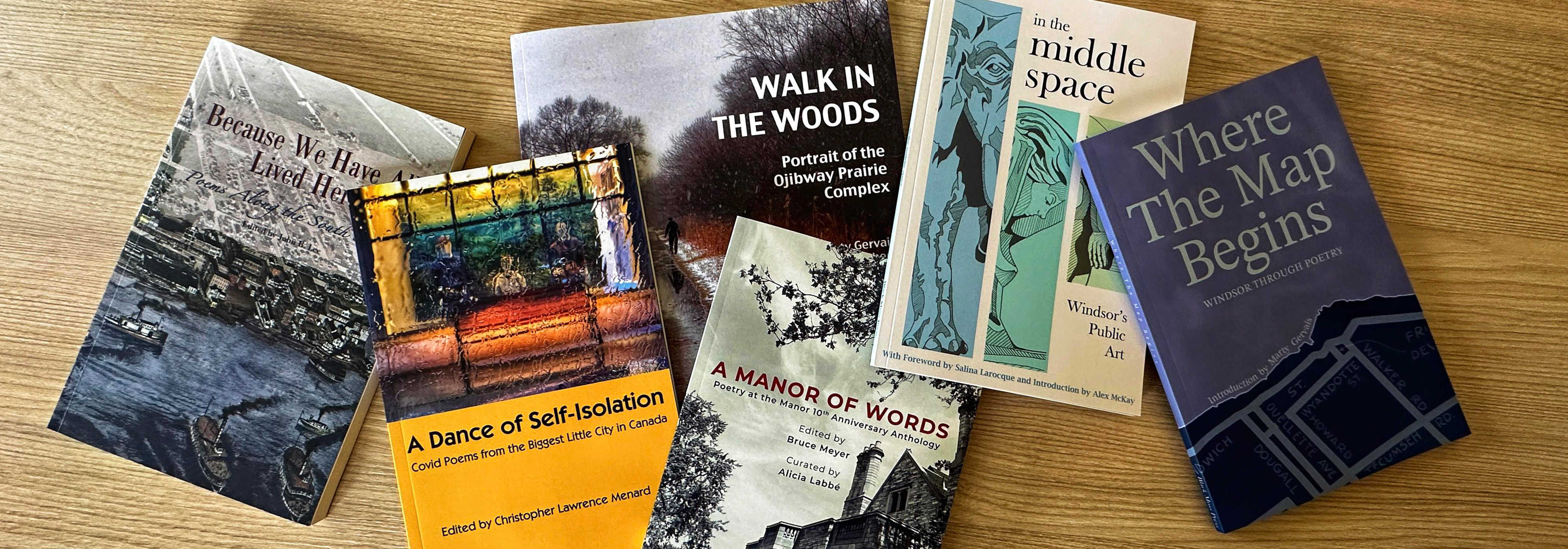 Six poetry books on a desk