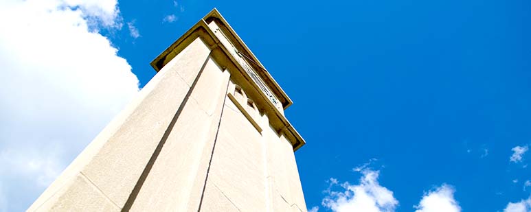 Sundial atop a tall granite obelisk.