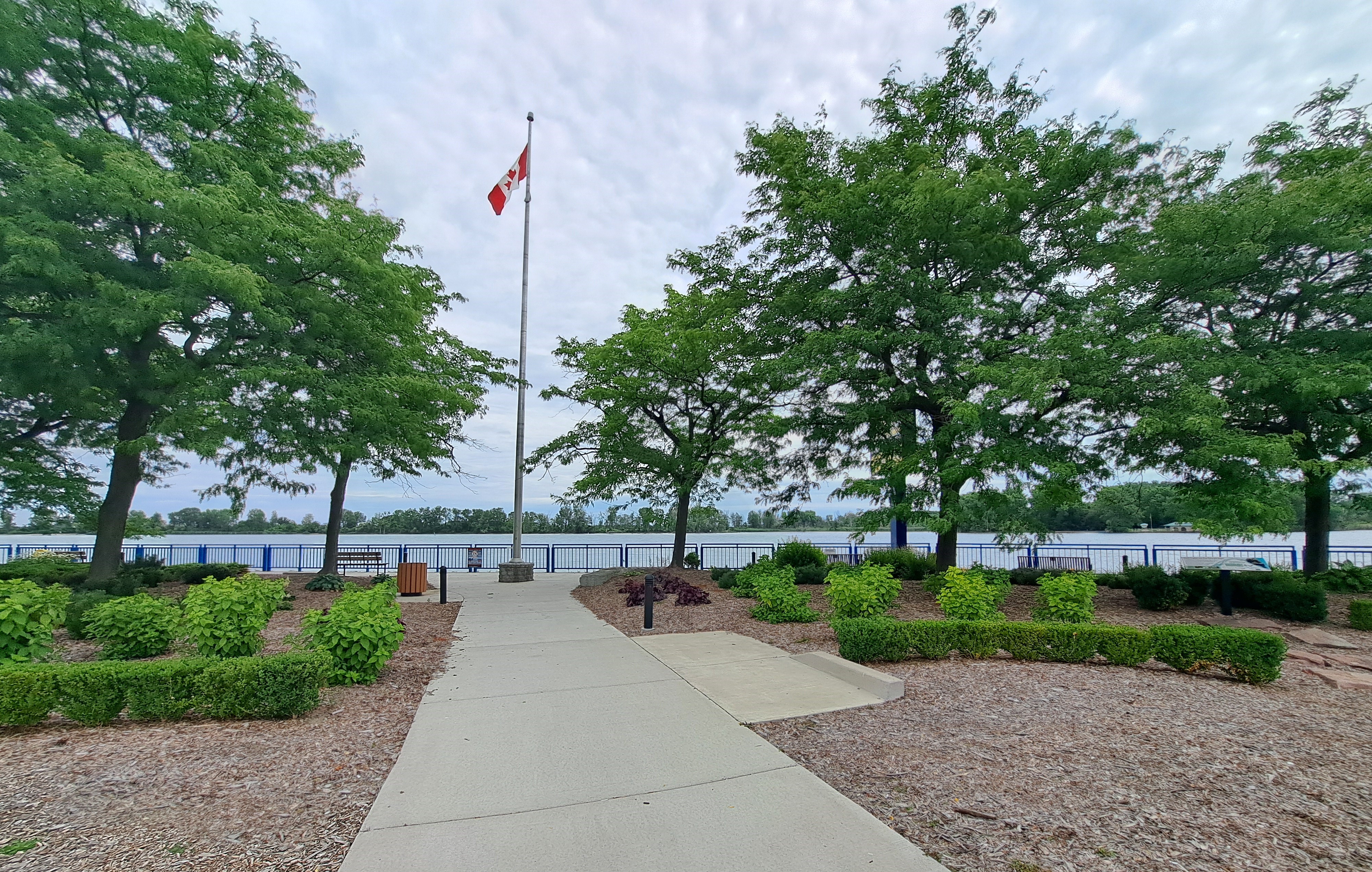 Paved path leading to Canadian flag overlooking the Detroit River